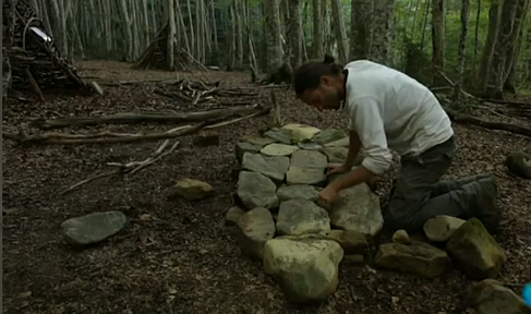 Hombre colocando piedras en el campo