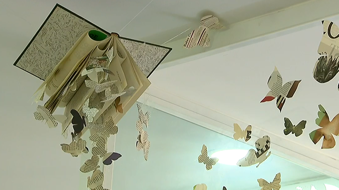 Libro colgado con mariposas de papel