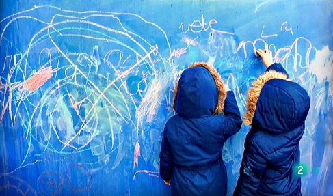 Dos niños pintando en una pared