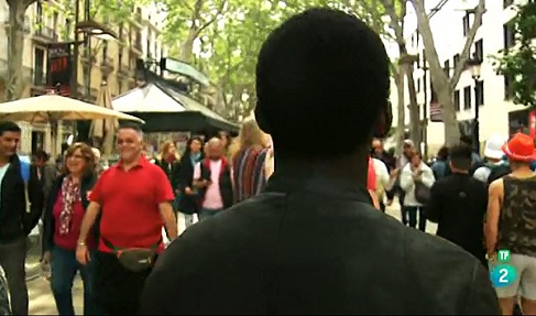 Persona de color de espaldas andando por la calle