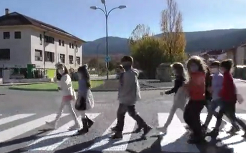 Niños con mascarilla cruzando un paso de peatones