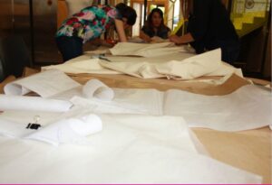 Mujeres cortando tela con patrones